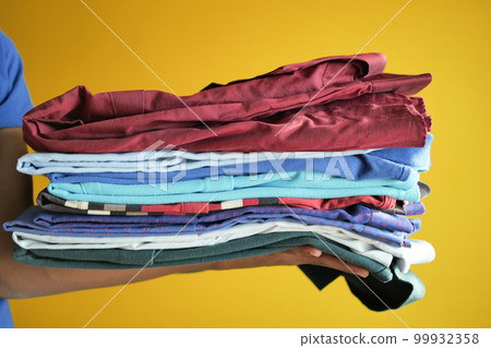 men holding stack of shirts  99932358