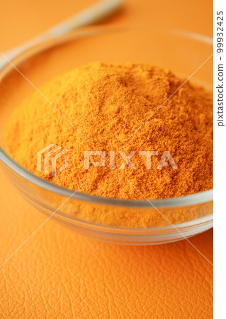 turmeric root powder in a bowl on orange background turmeric root powder in a bowl on orange background 99932425