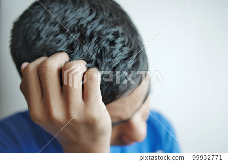 teenage boy Scratching Head Against black background . 99932771