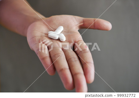 Close up of man hand holding pills with copy space  99932772