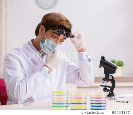 Young chemist working in the lab 99933577