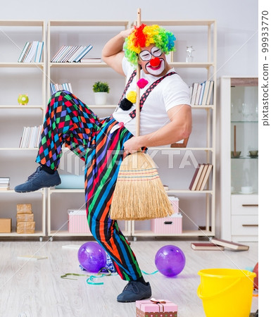 Funny clown doing cleaning at home 99933770