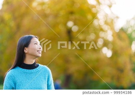 Distracted asian woman looking up in a park 99934186