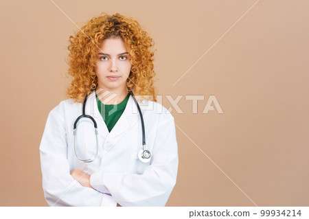 Serious female doctor in lab coat with crossed arms 99934214