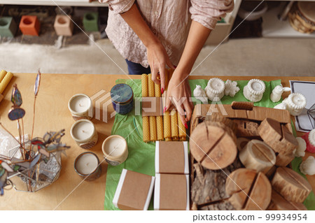 Close up of woman is packing handmade candles for selling in own home decor studio 99934954