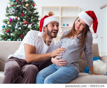 Young family expecting child baby celebrating christmas 99935144