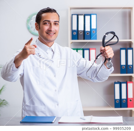 Young male doctor at the reception in the hospital 99935209