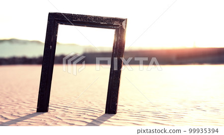 Empty wooden picture frame on the beach sand Empty wooden picture frame on the beach sand 99935394