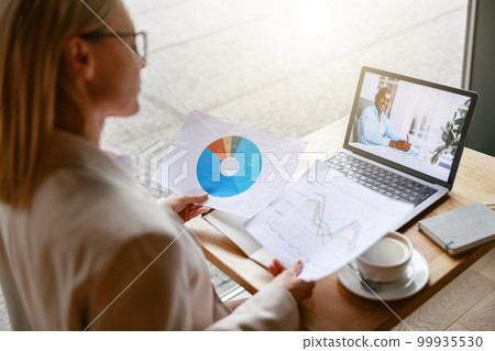 Businesswoman making online videoconference and demonstrate financial graphs to colleague in cafe 99935530