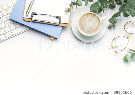 Modern white office desk table with laptop, notebook and other supplies. 99935600