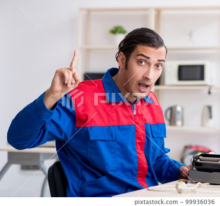 Young repairman repairing air-conditioner at warranty center Young repairman repairing air-conditioner at warranty center 99936036