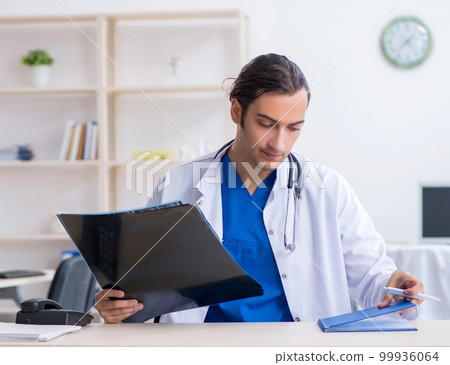 Young male doctor working in the clinic Young male doctor working in the clinic 99936064