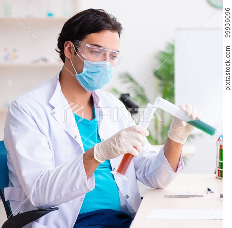 Young male chemist working in the lab Young male chemist working in the lab 99936096