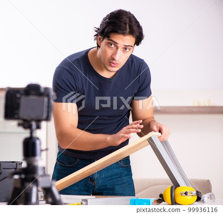 Young male repairman recording video for his blog Young male repairman recording video for his blog 99936116