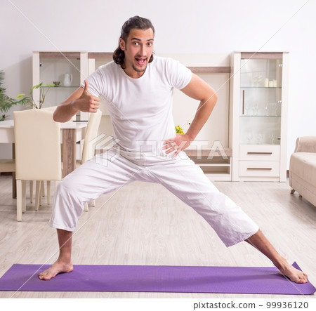 Young man doing physical exercises at home Young man doing physical exercises at home 99936120