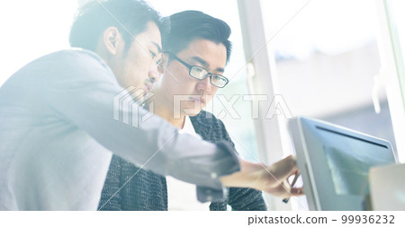 two young asian corporate executives working together using desktop computer two young asian corporate executives working together using desktop computer 99936232