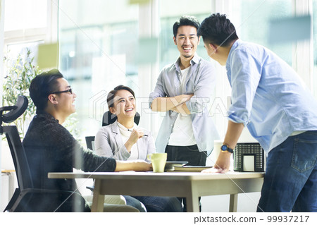 group of four happy young asian corporate people teammates meeting discussing business in office 99937217