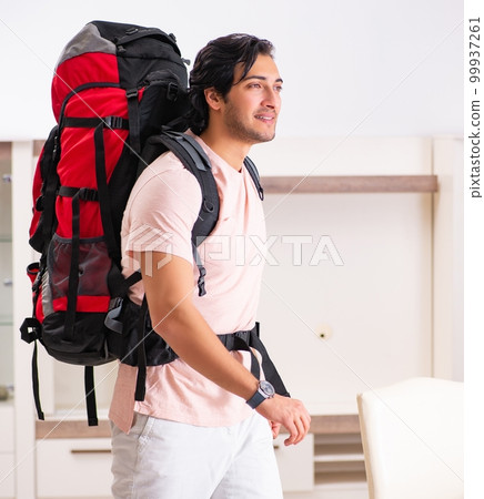 Young male tourist preparing for trip at home Young male tourist preparing for trip at home 99937261