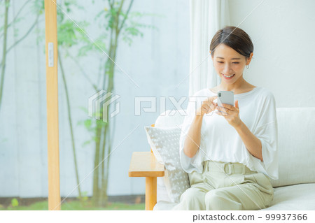 Woman in the living room Smartphone 99937366