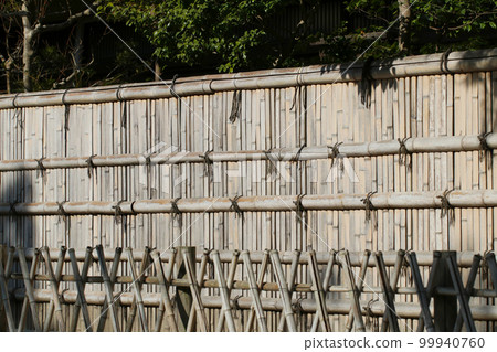 A traditional Japanese long fence made of woven bamboo. A photo with a Japanese taste that is whitened by the sun. 99940760