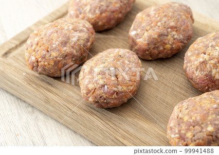 raw homemade meatballs on a massive board made of natural wood 99941488