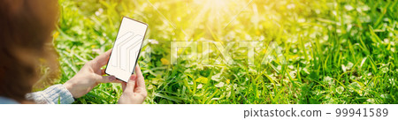 Woman holding in her hands smartphone with mockup screen. Woman holding in her hands smartphone with mockup screen. 99941589