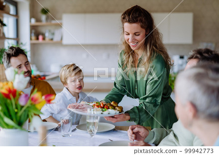 Happy multigenertional family having Easter dinner together. 99942773