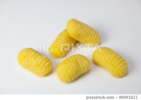 Pile of yellow eggs gnocchi dough dumplings isolated over the white background 99943021