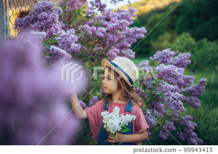 Portrait of little girl with lilac, spring mood. 99943415