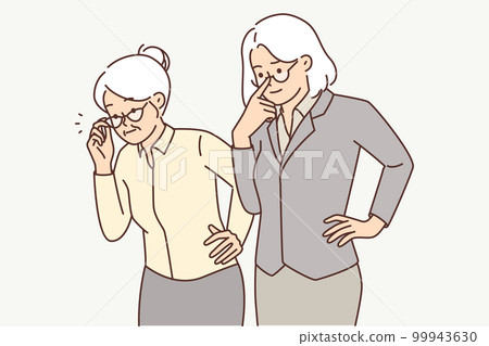 Two elderly women in business clothes carefully look to side watching work of young employees 99943630