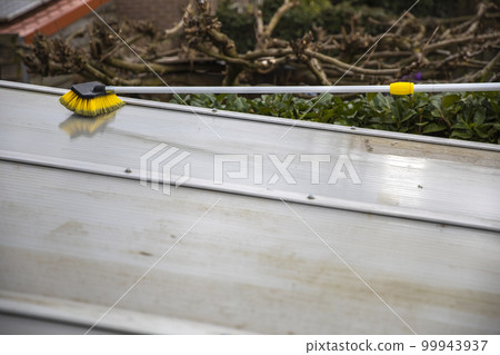 Washing the patio pergola roof cover made of aluminum. removing the dirty algae with brush soap and water close up in garden from a house terrace Washing the patio pergola roof cover made of aluminum. removing the dirty algae with brush soap and water close up in garden from a house terrace 99943937