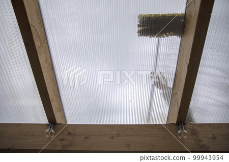 Washing the patio pergola roof cover made of aluminum. removing the dirty algae with brush soap and water close up in garden from a house terrace 99943954