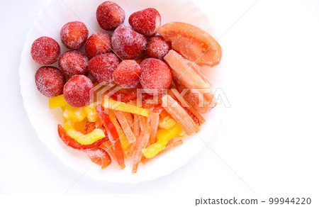 Frozen vegetables on a plate, frozen strawberries, frozen paprika, frozen tomatoes, frozen carrots Frozen vegetables on a plate, frozen strawberries, frozen paprika, frozen tomatoes, frozen carrots 99944220