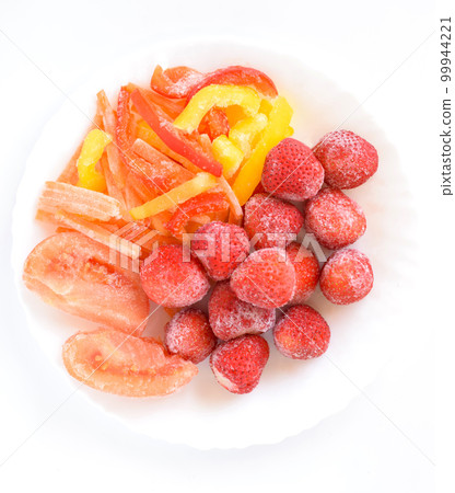 Frozen vegetables on a plate, frozen strawberries, frozen paprika, frozen tomatoes, frozen carrots Frozen vegetables on a plate, frozen strawberries, frozen paprika, frozen tomatoes, frozen carrots 99944221