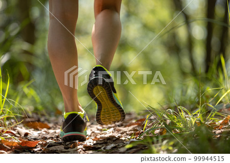 Woman runner running on forest trail Woman runner running on forest trail 99944515