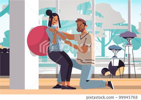 fitness trainer with young female patient doing squats with fit ball generation z lifestyle concept modern gym interior fitness trainer with young female patient doing squats with fit ball generation z lifestyle concept modern gym interior 99945768