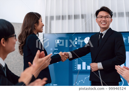 Employees shake hand for symbol of harmony after successful business meeting. Employees shake hand for symbol of harmony after successful business meeting. 99946524