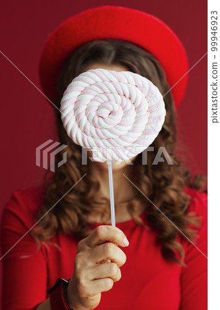 40 years old woman in red dress and beret on red background 40 years old woman in red dress and beret on red background 99946923