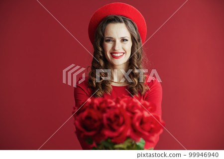 smiling elegant 40 years old woman in red dress and beret 99946940