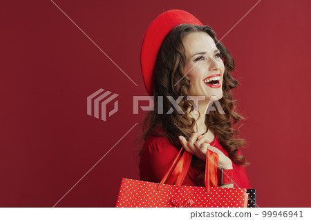 happy woman in red dress and beret isolated on red background 99946941