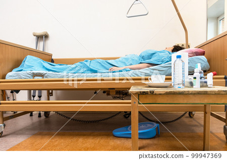 hospital bed with sick person and table at home 99947369