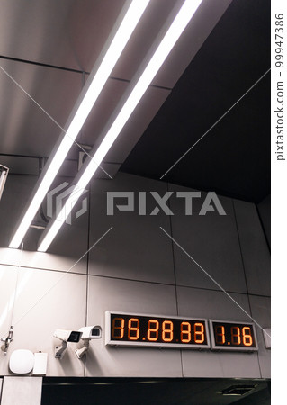 digital clock and surveillance cctv camera on wall 99947386