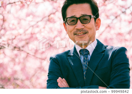 Cherry blossoms in full bloom and an old man in a suit 99949842