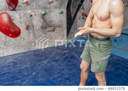 climbing magnesium on the hands of an athlete in a bouldering center climbing magnesium on the hands of an athlete in a bouldering center 99952378