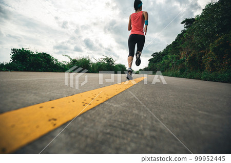 Fitness woman running on seaside trail in the morning 99952445