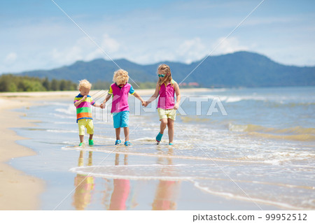 Kids on tropical beach. Children playing at sea. 99952512