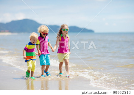 Kids on tropical beach. Children playing at sea. 99952513