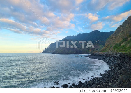 A picturesque beautiful sunset on the shores of the island of Madeira in the Atlantic Ocean. A picturesque beautiful sunset on the shores of the island of Madeira in the Atlantic Ocean. 99952621