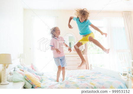 Child playing in bed. Kids room. Boy at home. 99953152