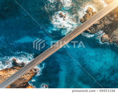 Aerial view of bridge, sea with waves and stones at sunset Aerial view of bridge, sea with waves and stones at sunset 99953198